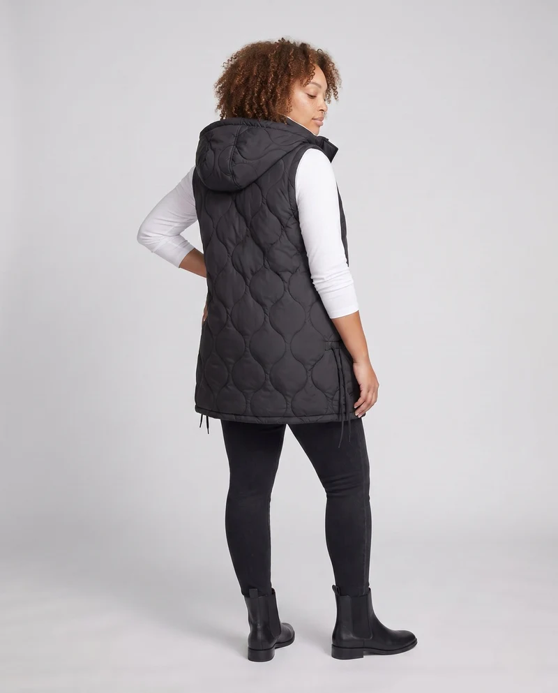 Damen leichte gepolsterte lange Weste mit ergonomischer Wellensteppung, integrierter Kapuze und verstellbarem Saum