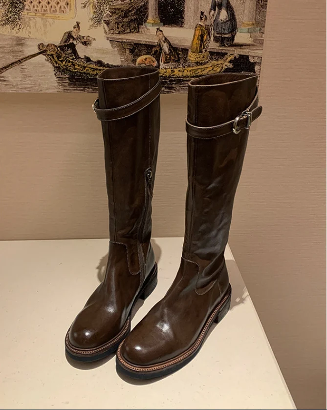 Damen kniehohe Lederstiefel mit flacher Profilsohle und Ziergurt Drune